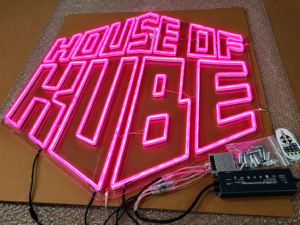 Custom pink LED neon sign fabricated on a clear acrylic backing for interior branding and commercial display applications.