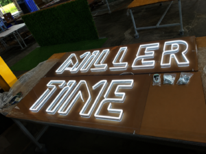 Custom cool white neon LED chandelier fabricated and illuminated during production before installation.