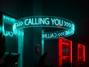 Custom suspended LED neon chandelier installation with illuminated circular acrylic display for a branded event venue.