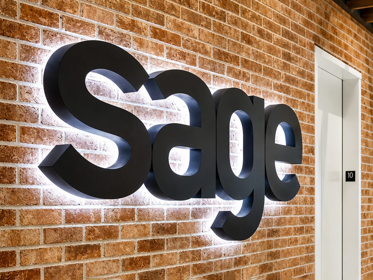 Custom reverse lit halo letters mounted on a brick office feature wall with white LED halo illumination for corporate interior branding.