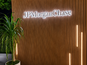 Custom white face reverse lit halo letters mounted on a wood slat wall for outdoor corporate event branding and hospitality environments.