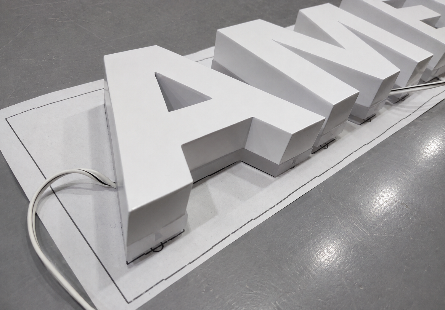 White American Express halo-lit letters glowing during a workshop test