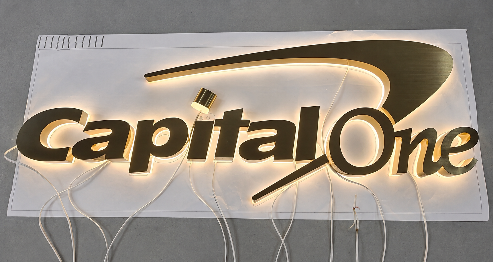 Capital One bronze halo-lit logo letters illuminated during workshop testing