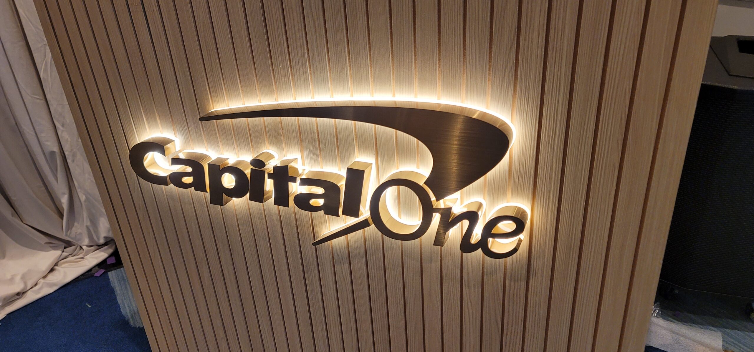 Capital One bronze halo-lit logo mounted on a wood DJ booth at a Los Angeles event