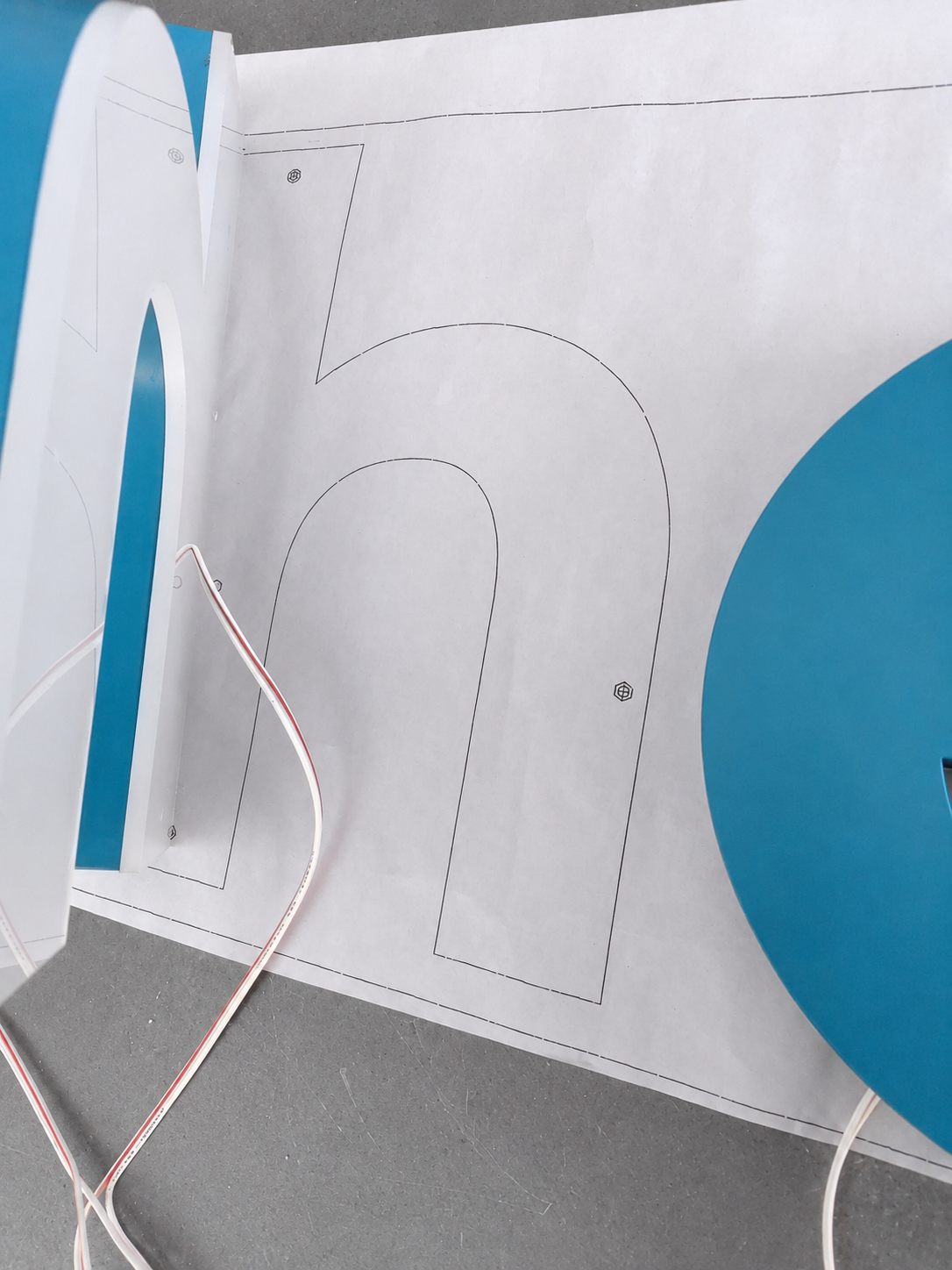 Close-up of Checkr logo letter wiring positioned over a mounting template