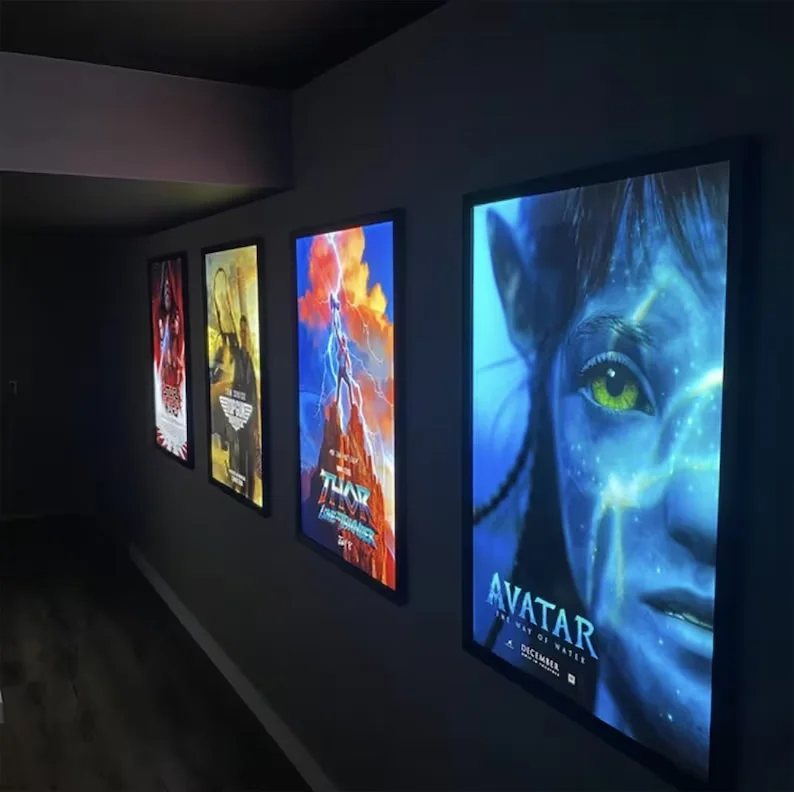 Illuminated movie poster frames lining a dark home theater hallway