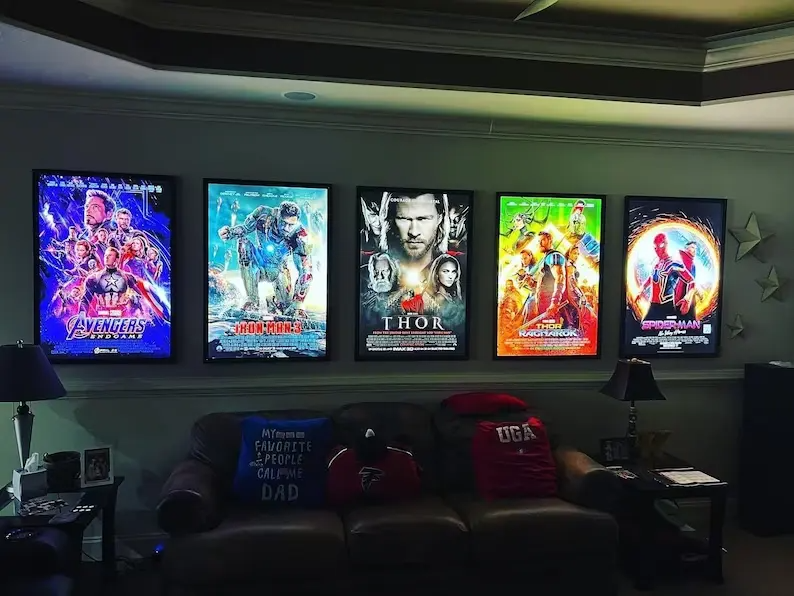 Five illuminated LED movie poster frames installed above home theater seating