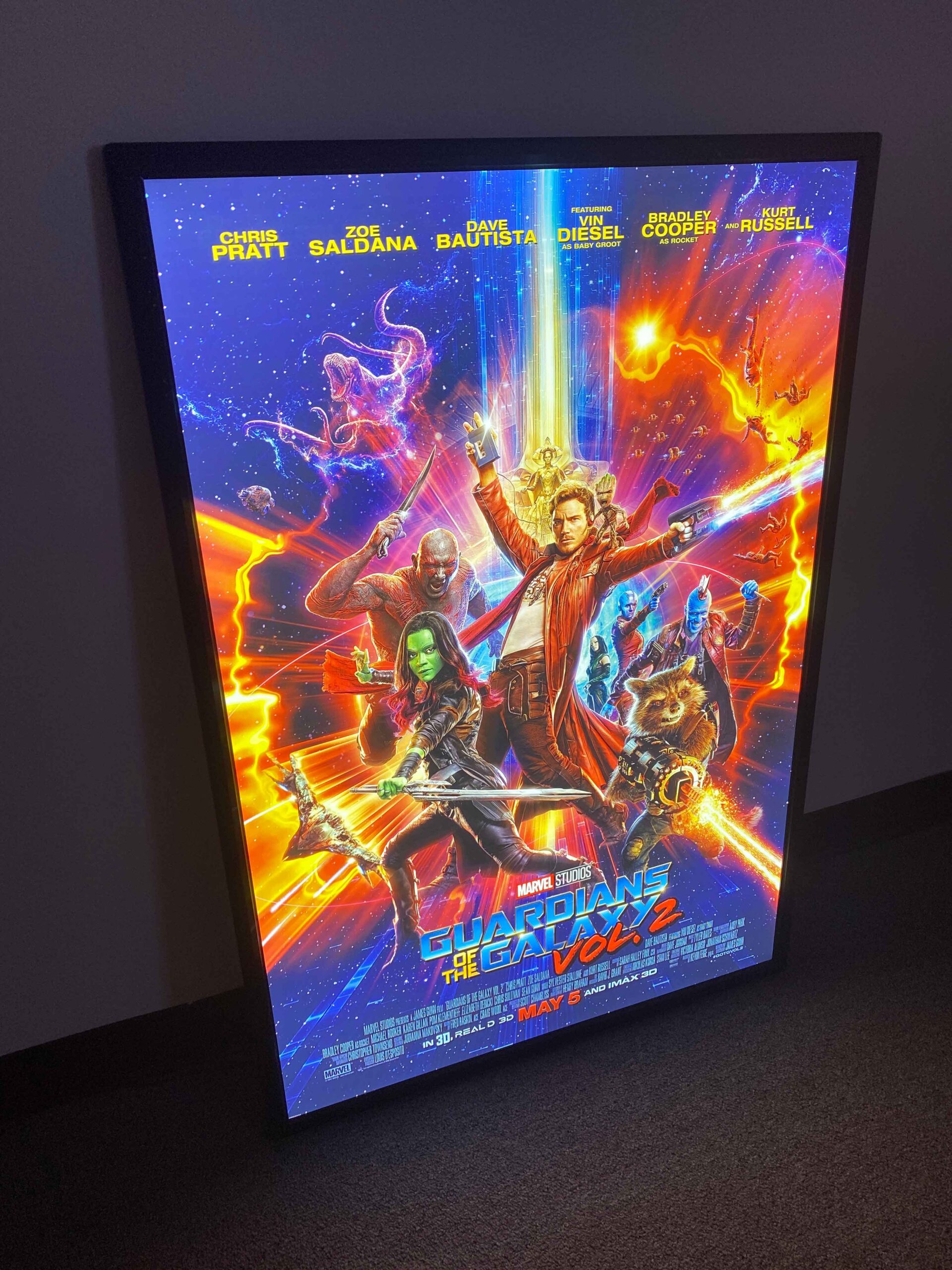 Bright illuminated movie poster lightbox with a slim black frame