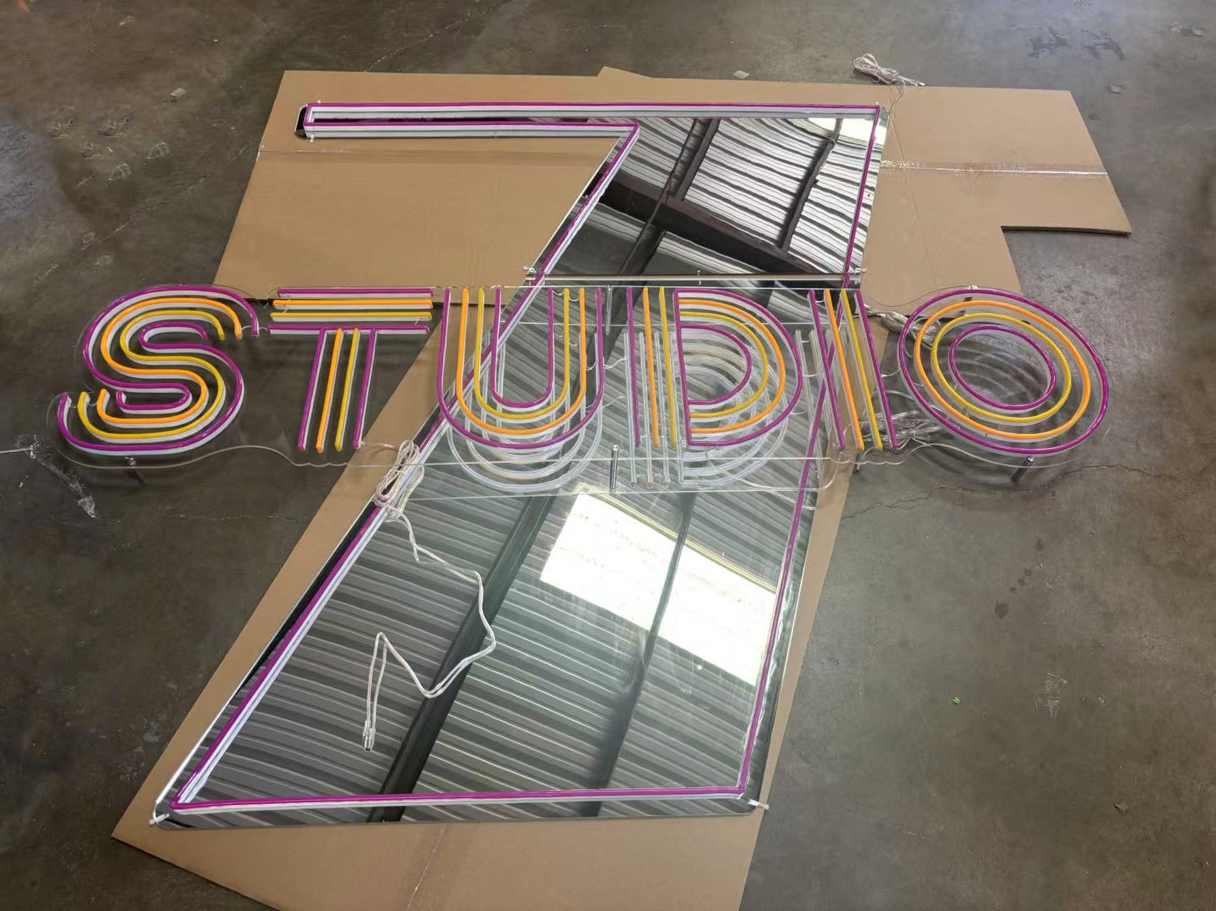 Custom Studio 7 neon sign components assembled on mirrored acrylic during fabrication