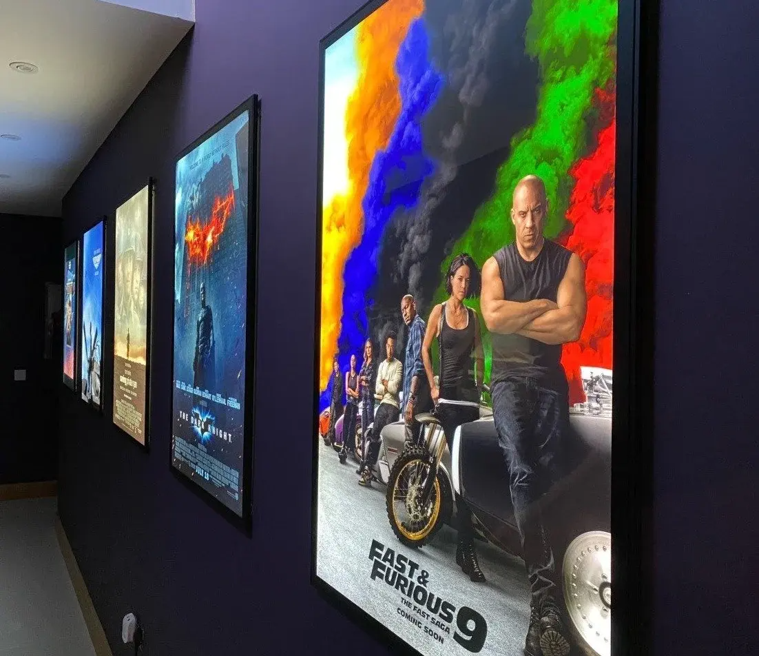 Wall-mounted LED movie poster lightboxes viewed from an angle