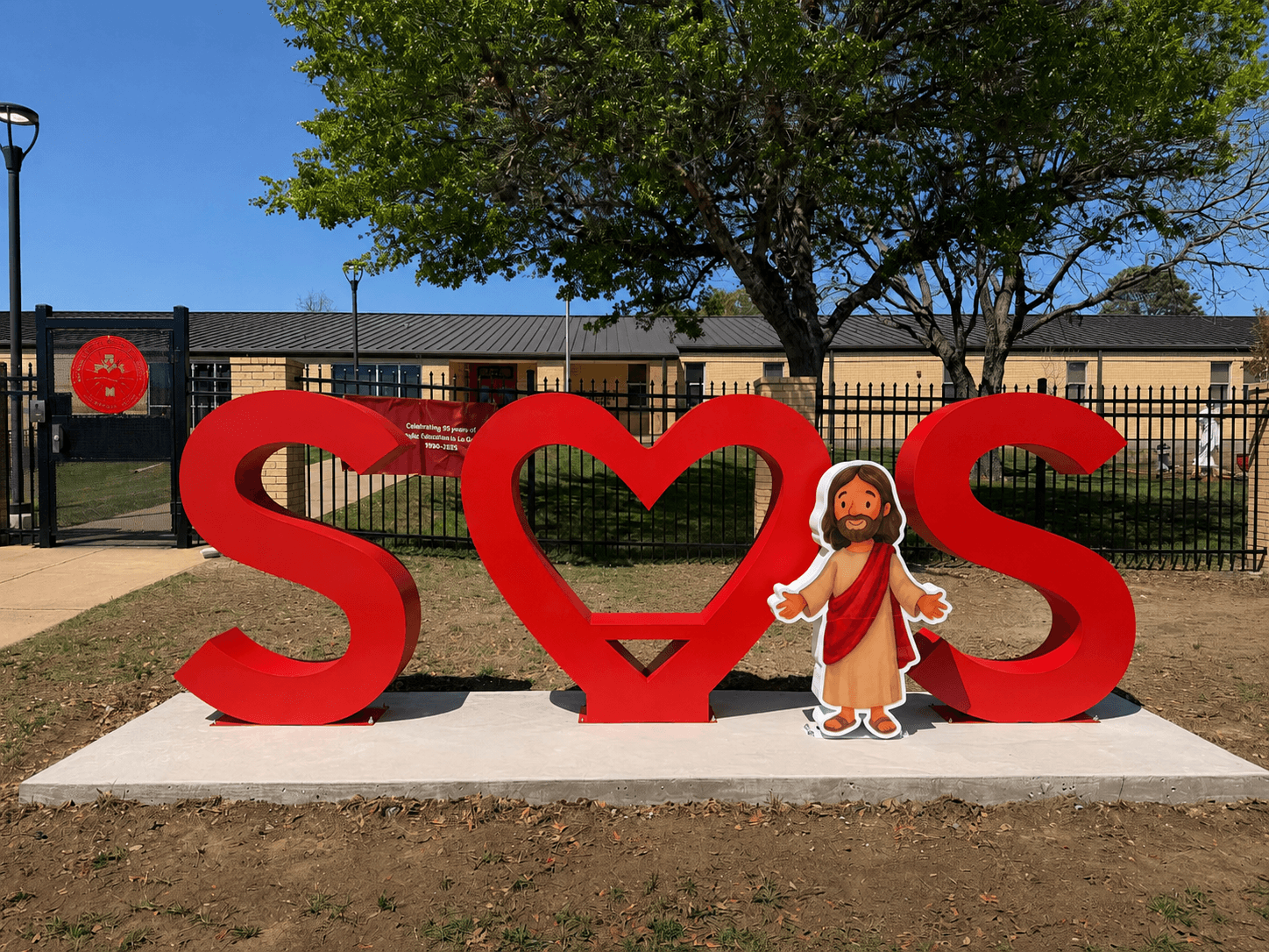 Sacred Heart oversized outdoor dimensional letters installed on a concrete monument base