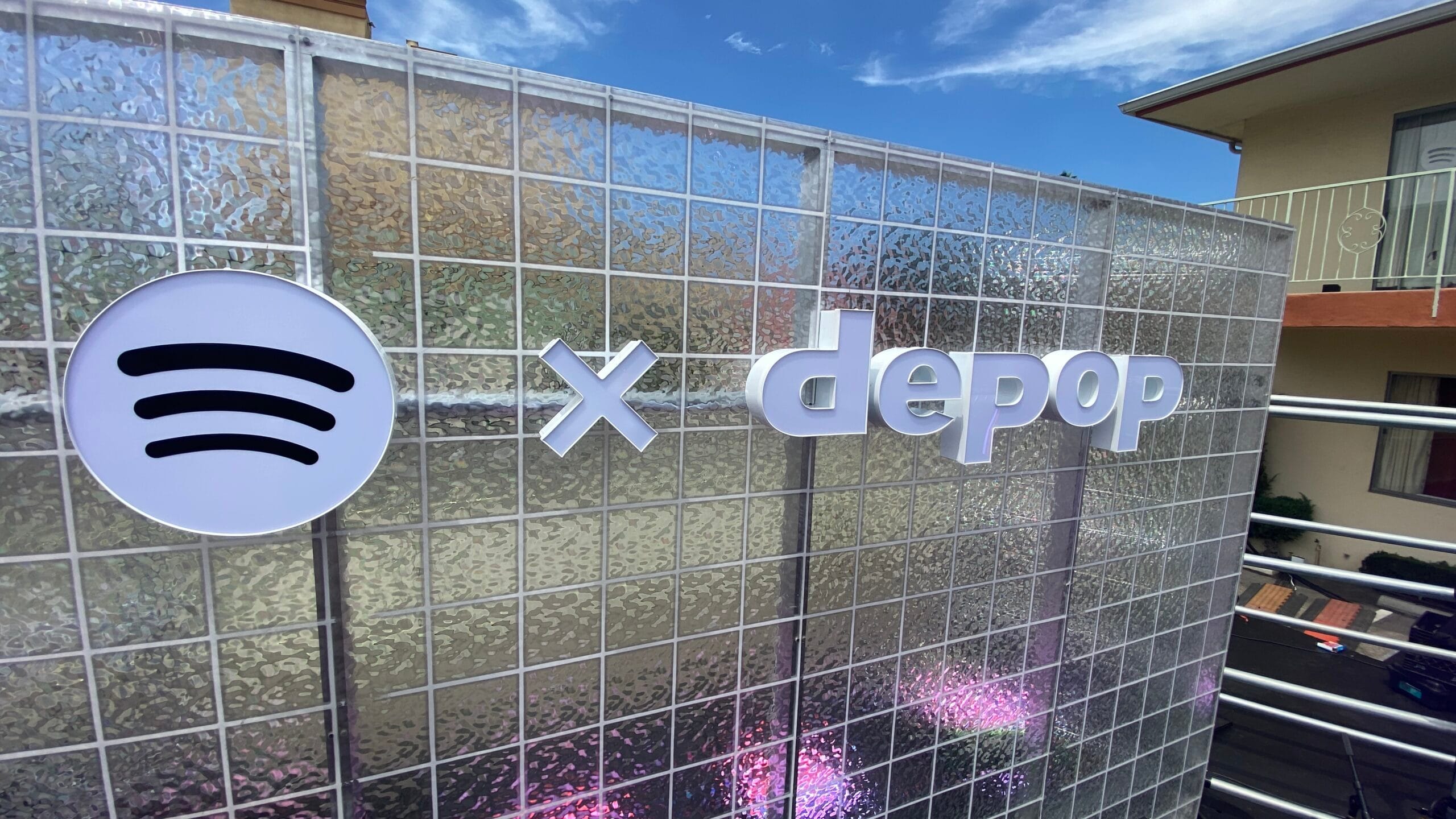 Spotify x Depop dimensional logo signage on a reflective outdoor event backdrop