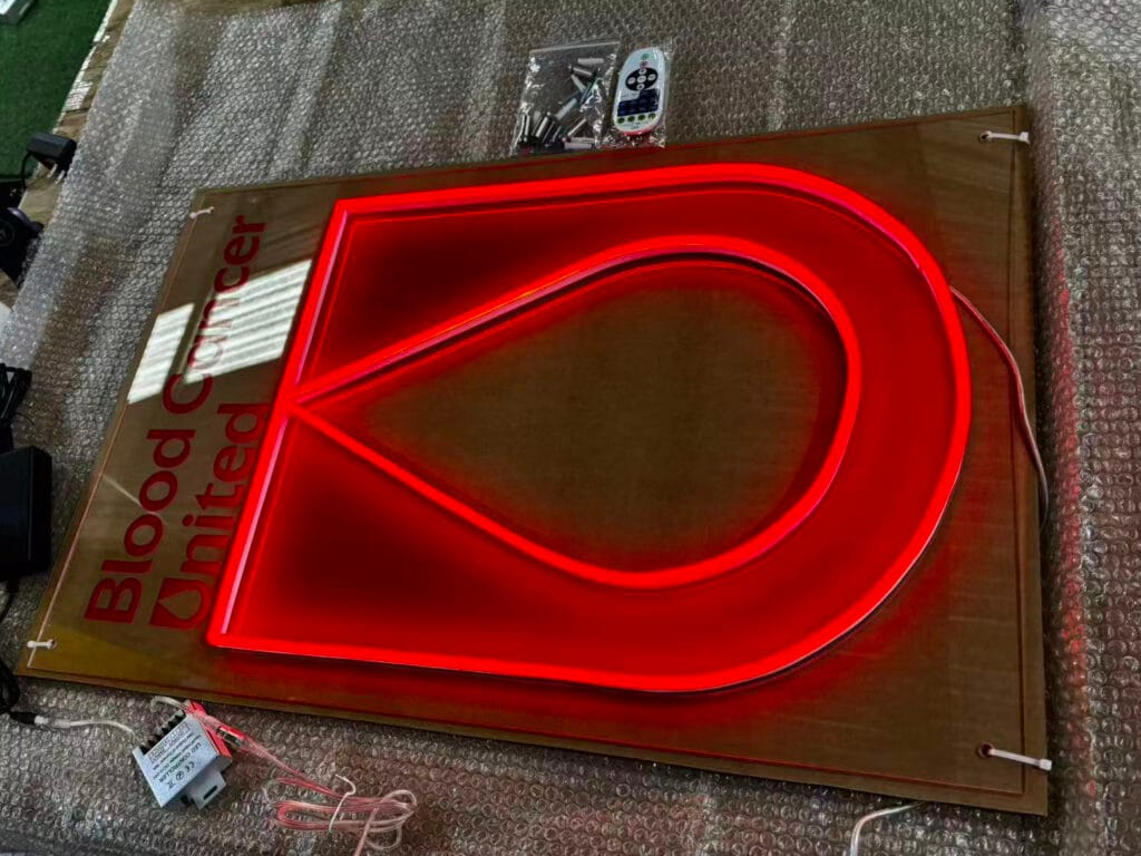 Close-up of the Blood Cancer United LED neon sign, showing UV-printed lettering and red logo detail.