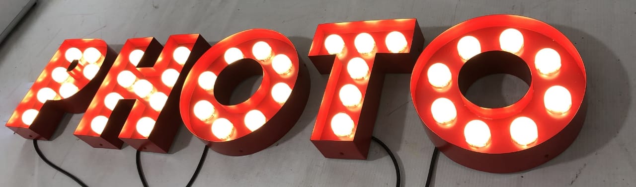 Full set of red PHOTO marquee letters illuminated with warm white LED bulbs.