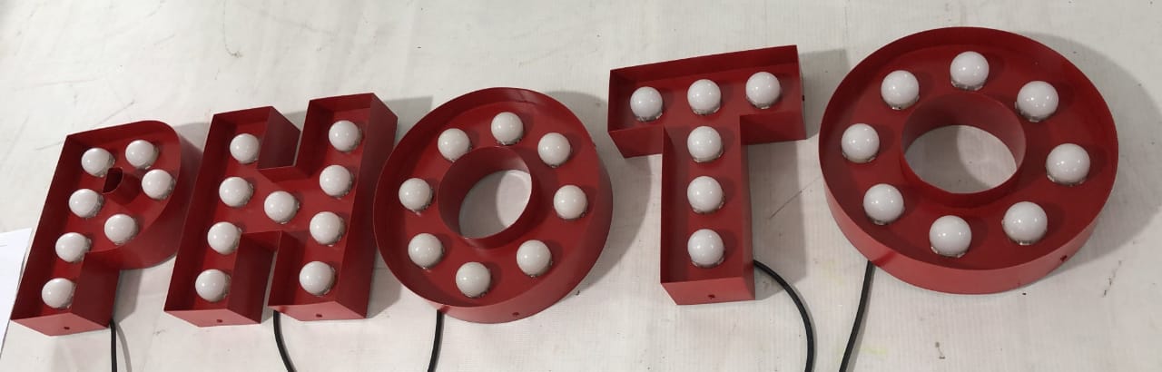 Full set of PHOTO marquee letters with warm white bulbs switched off.